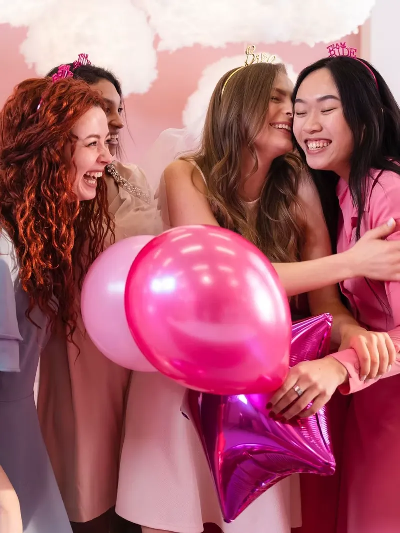A group celebrating on a studio set with balloons