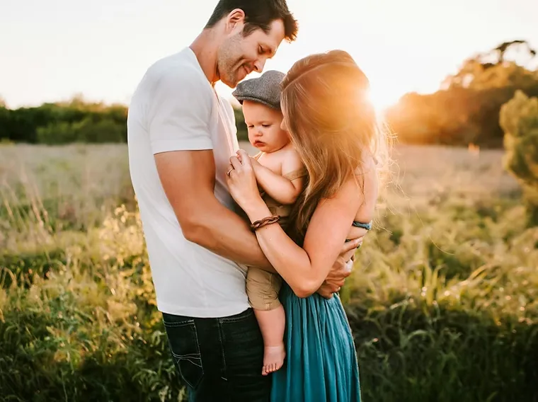 A family photographed outdoors in evening light