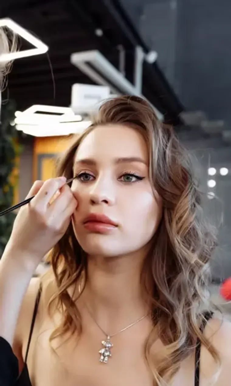 A makeup artist finishing a client's look before a shoot